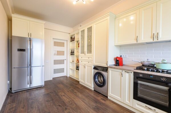 Przytulna, nowoczesna kuchnia w jasnych barwach, dokumenty potrzebne do zakupu mieszkania będą pomocne przy przewodnictwie w jej aranżacji.