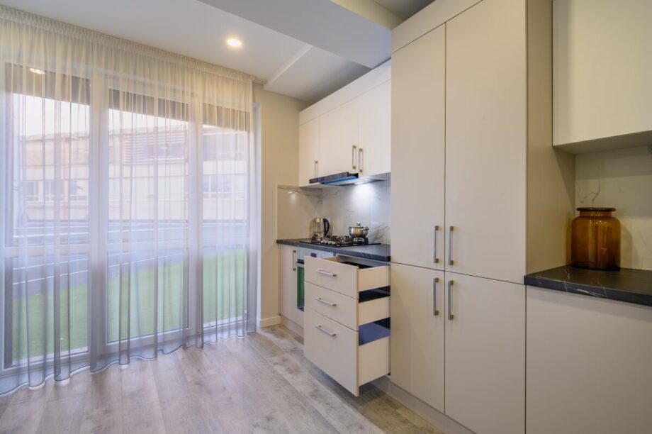 Nowoczesna kuchnia z dużymi oknami ilustruje innowacyjne rozwiązania nowoczesne mieszkania.