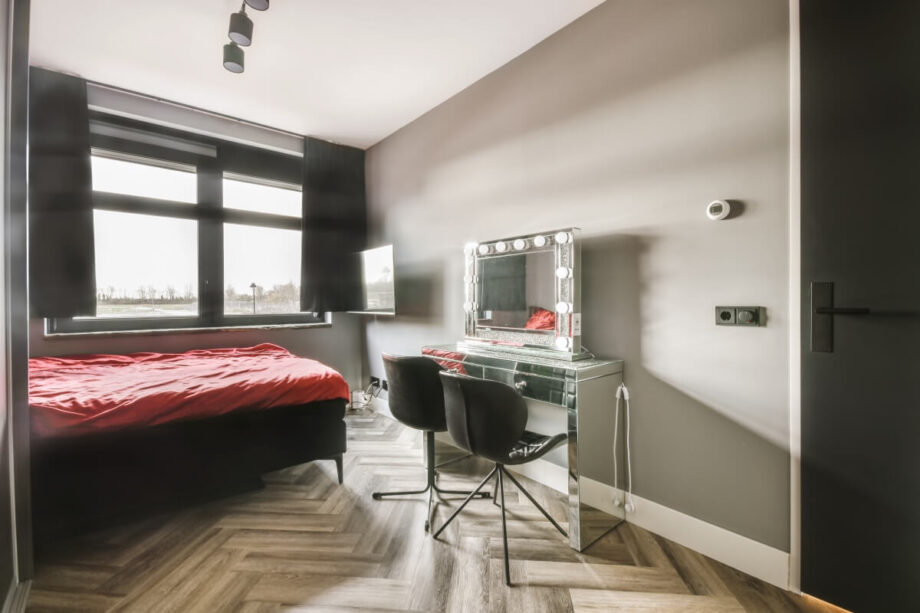 Stylowy pokój z dużym oknem i toaletką podpowiada najważniejsze kroki wybór mieszkania, takie jak oświetlenie i wystrój wnętrza.