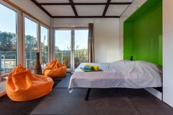 Wnętrze nowoczesnego mieszkania z dużymi oknami i jasną kolorystyką, odzwierciedlające najnowsze trendy budownictwo mieszkaniowe.